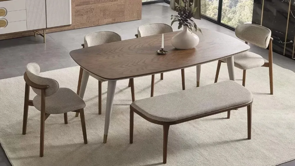 veliki trpezarijski sto od tamnog drveta, sa četiri stolice sa sivim materijalom i klupom od istih materijala