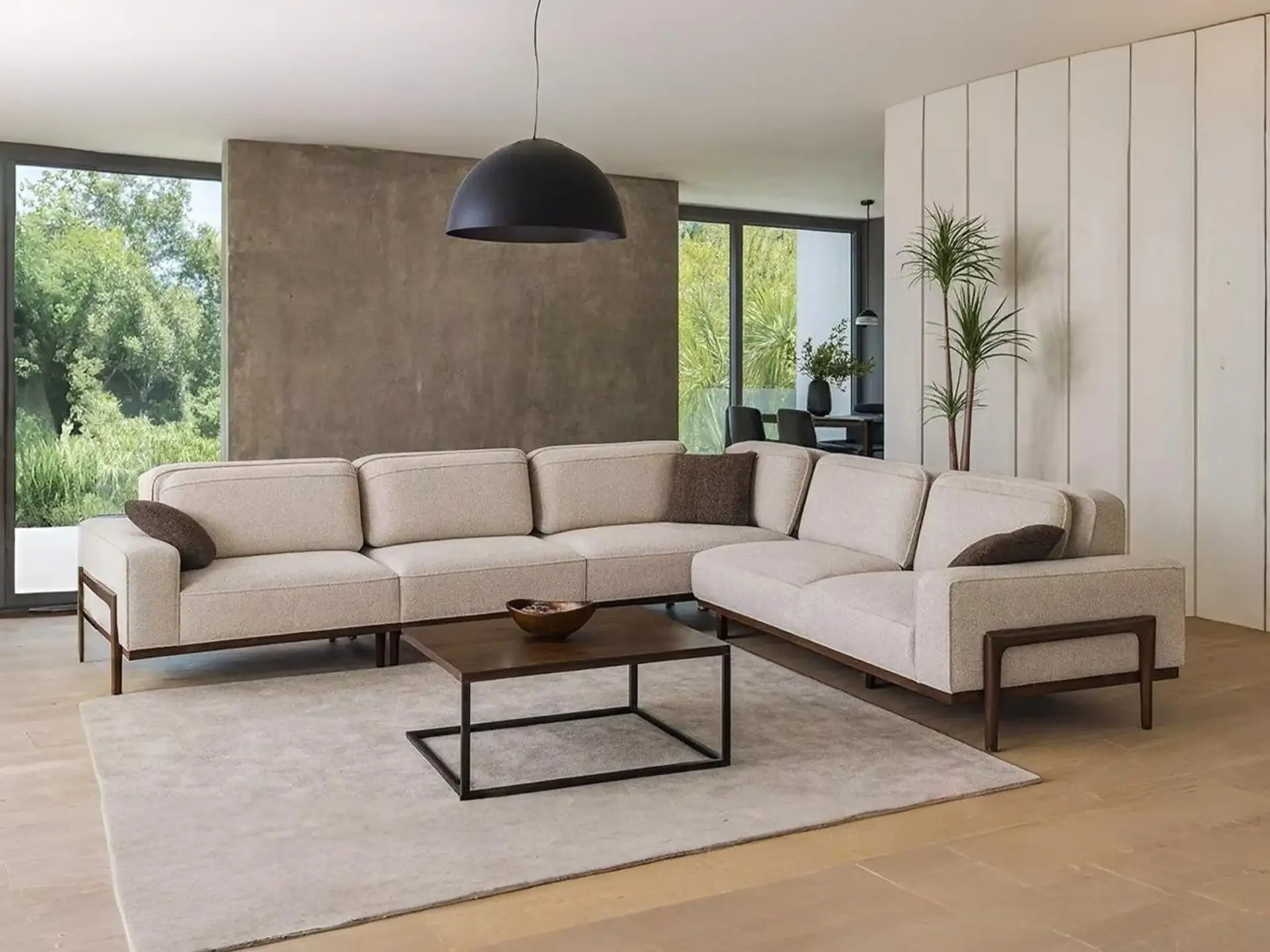 Krem ugaona garnitura sa usklađenim modernim klub stolom i dekorativnim jastucima. 